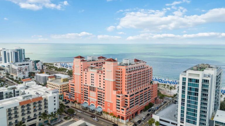 An aerial view of 301 S. Gulfview Blvd with the Gulf of Mexico behind it on a sunny day