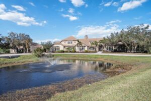 6200 Saddle Oak Trail in Sarasota FL - Aerial view across from a small lake with water fountain feature.