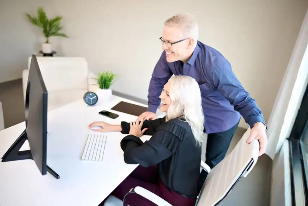 Bill & Cheryl McCue looking at computer in the office