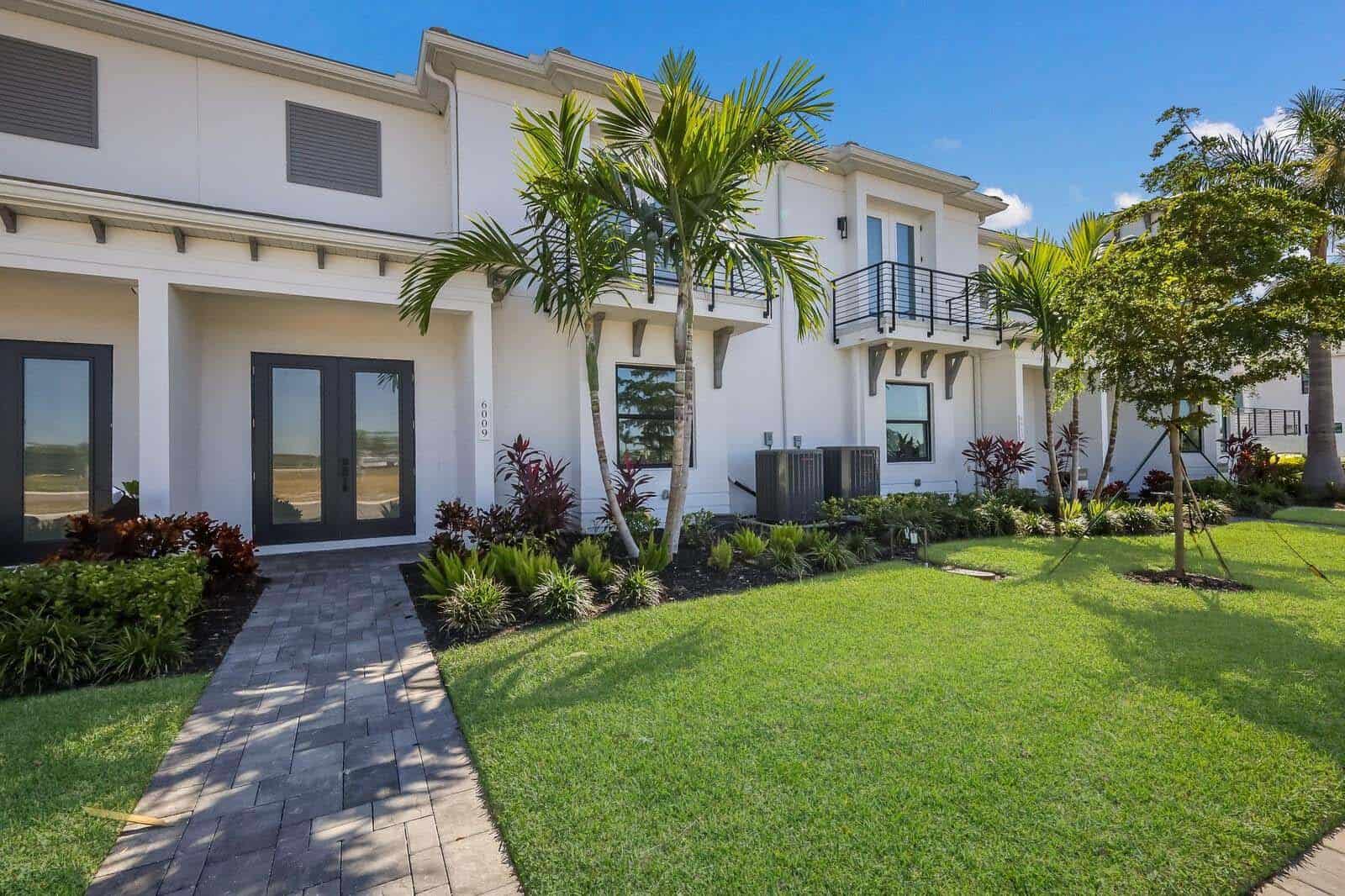 Townhome entrance with landscaped garden at Aqua Lagoon Townhomes in Bradenton, Florida