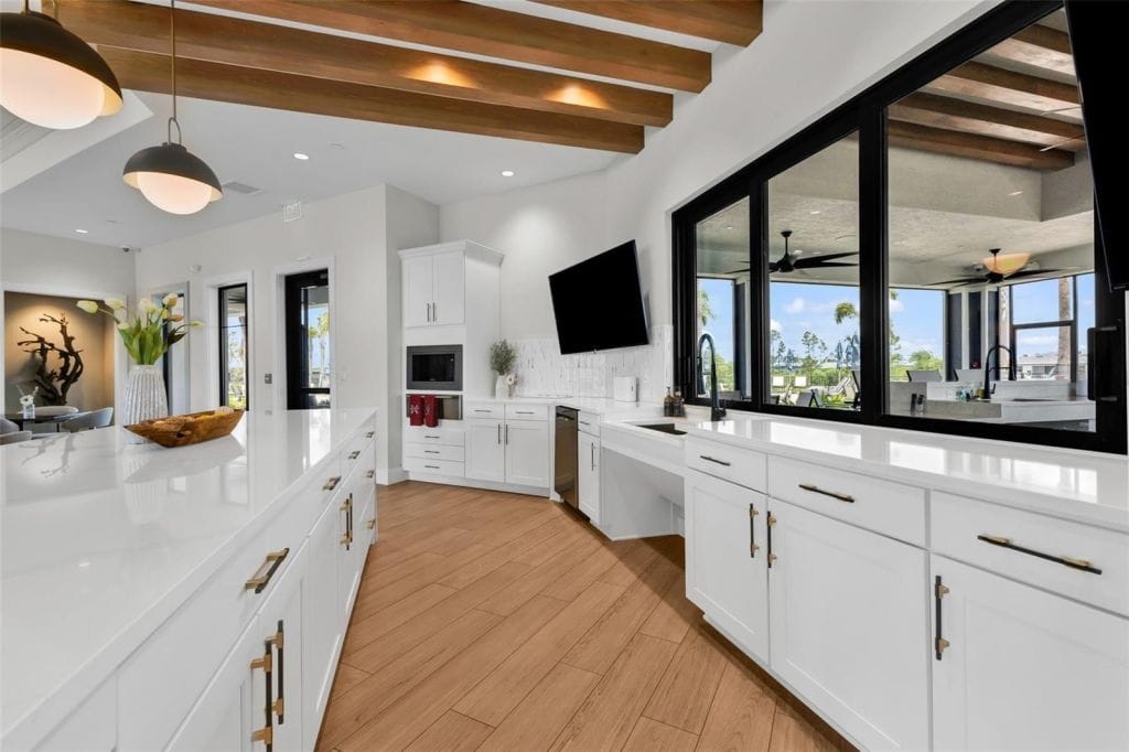 Modern kitchen with white cabinetry and windows at Arbor Oaks in North Port, Florida